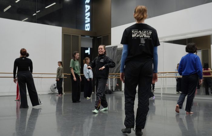 Dancers hold a moment of stillness in a dance studio.