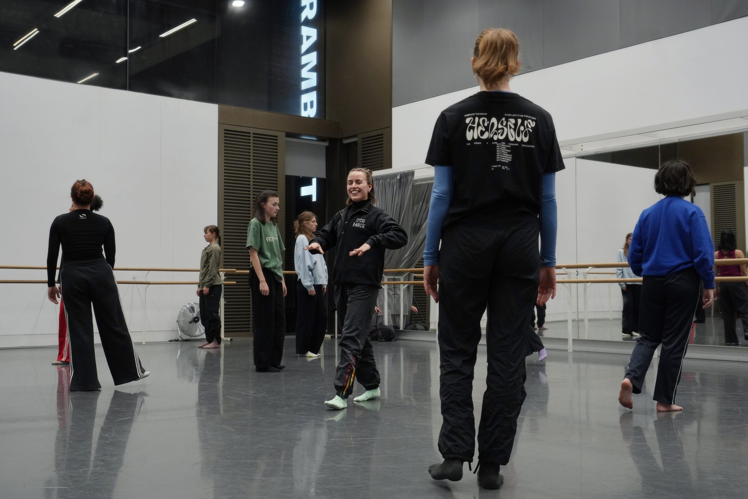 Dancers hold a moment of stillness in a dance studio.